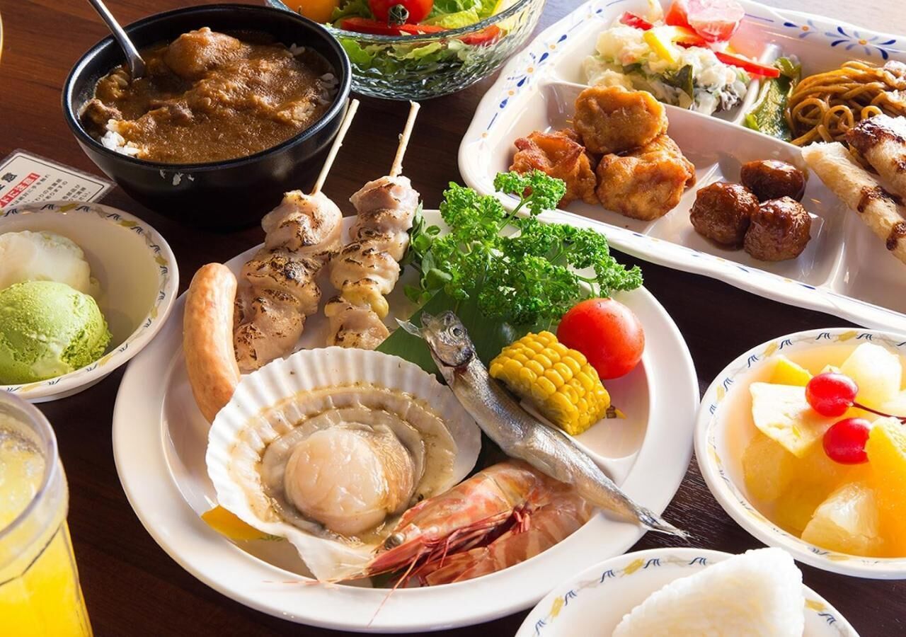 Variedad de platos que incluyen mariscos, verduras y carne, sugiriendo una amplia selección de comidas.