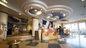 A hotel lobby with a reception desk, check-in counter, and seating area. - Hotel Gradisca (Rimini)