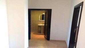 Pasillo que conduce a un baño con lavabo y espejo.