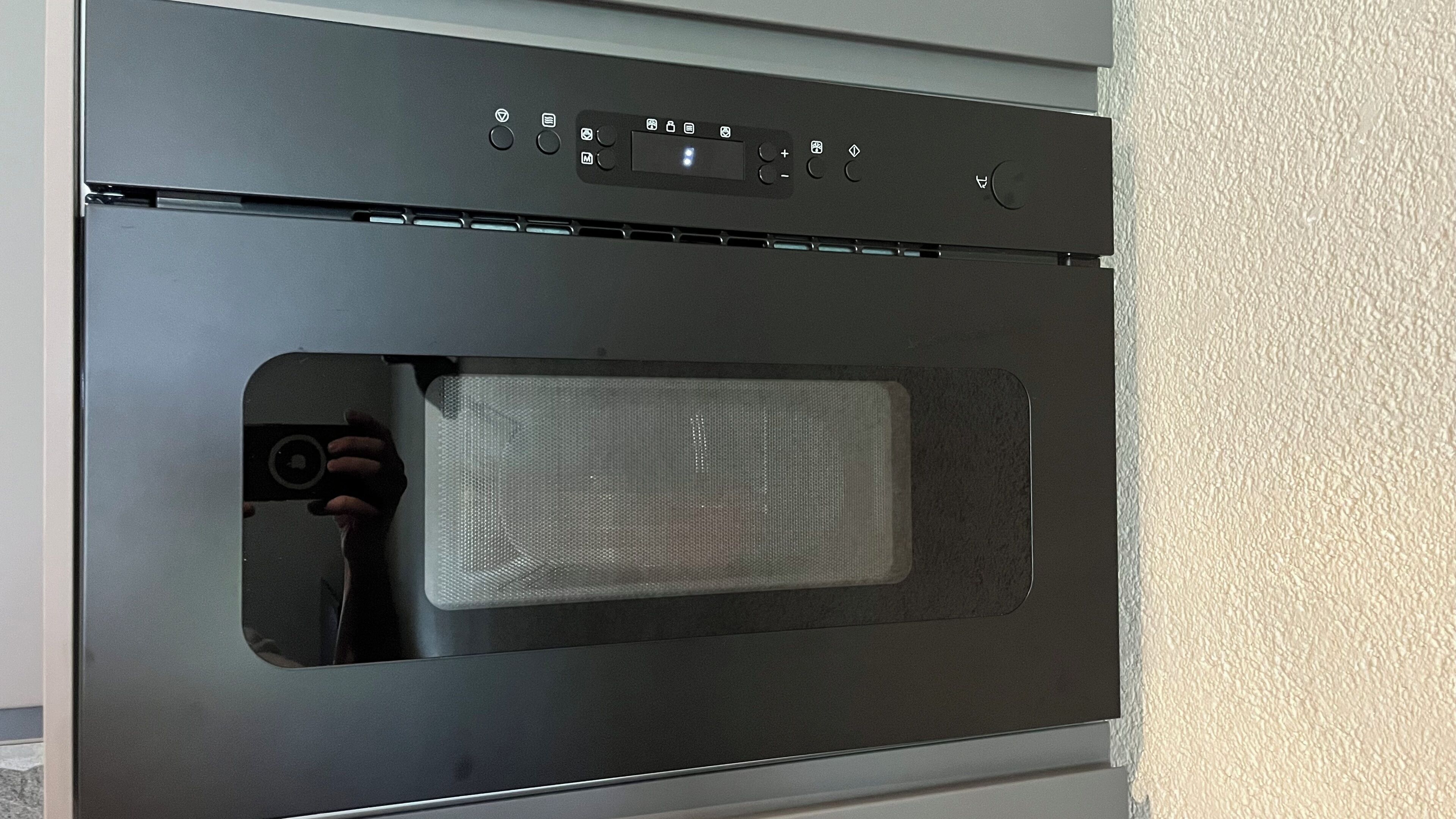 A modern kitchen with a built-in oven and microwave.