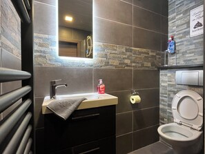 A bathroom with a sink, toilet, and a mirror. - Haus Tauern Am See (Heiterwang)