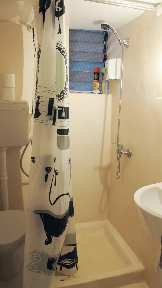 A bathroom with a shower, a toilet, and a sink.