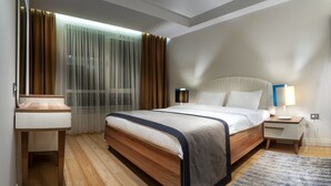 A hotel room with a wooden bed, two bedside tables, a nightstand, a large window with sheer curtains, and a view of the outdoors. - Armoni Residence (Istanbul)