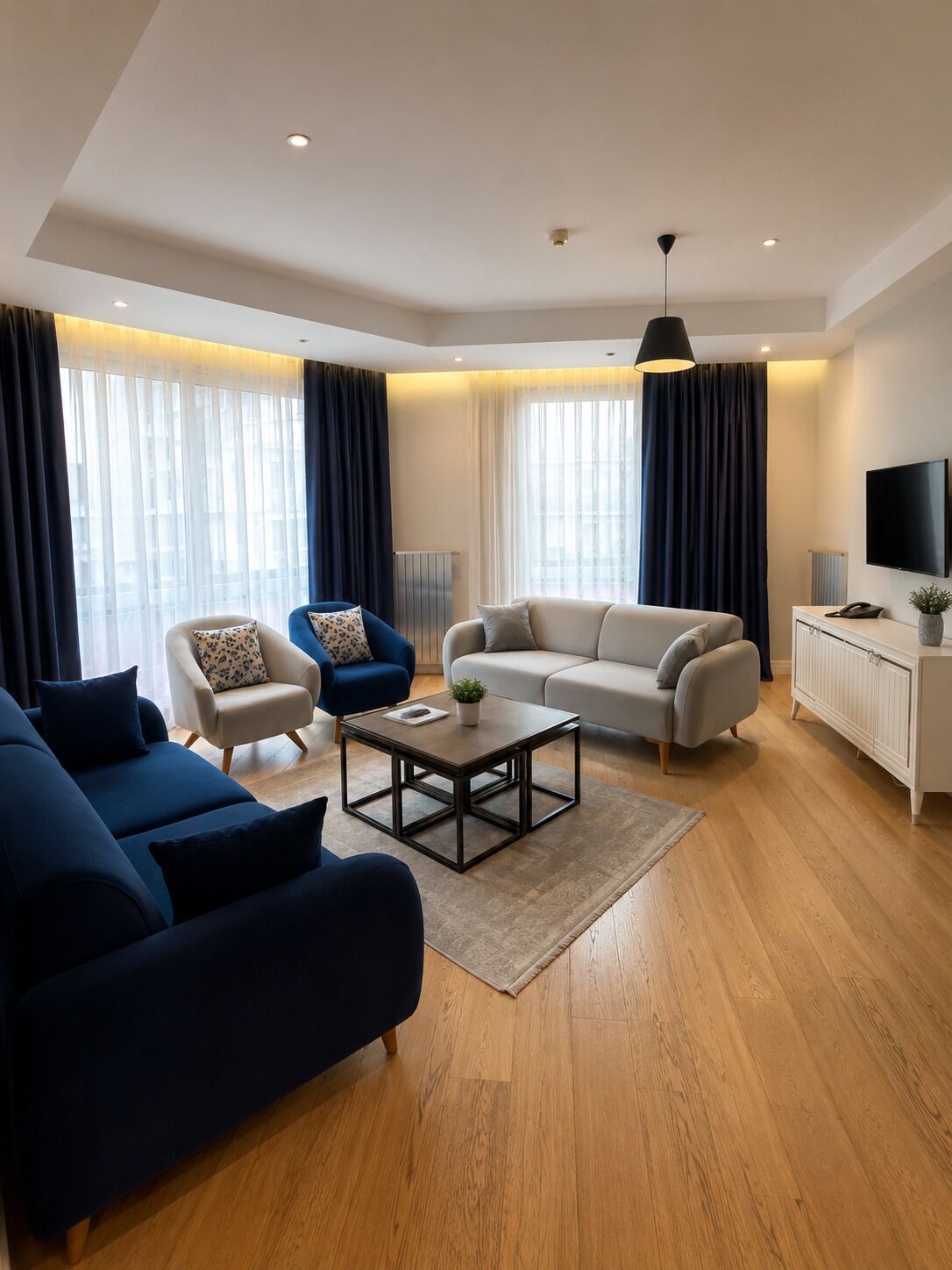 Een moderne woonkamer met een zithoek, een salontafel en een televisie.