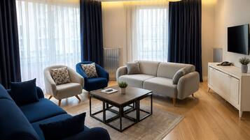 Een moderne woonkamer met een zithoek, een salontafel en een televisie.
