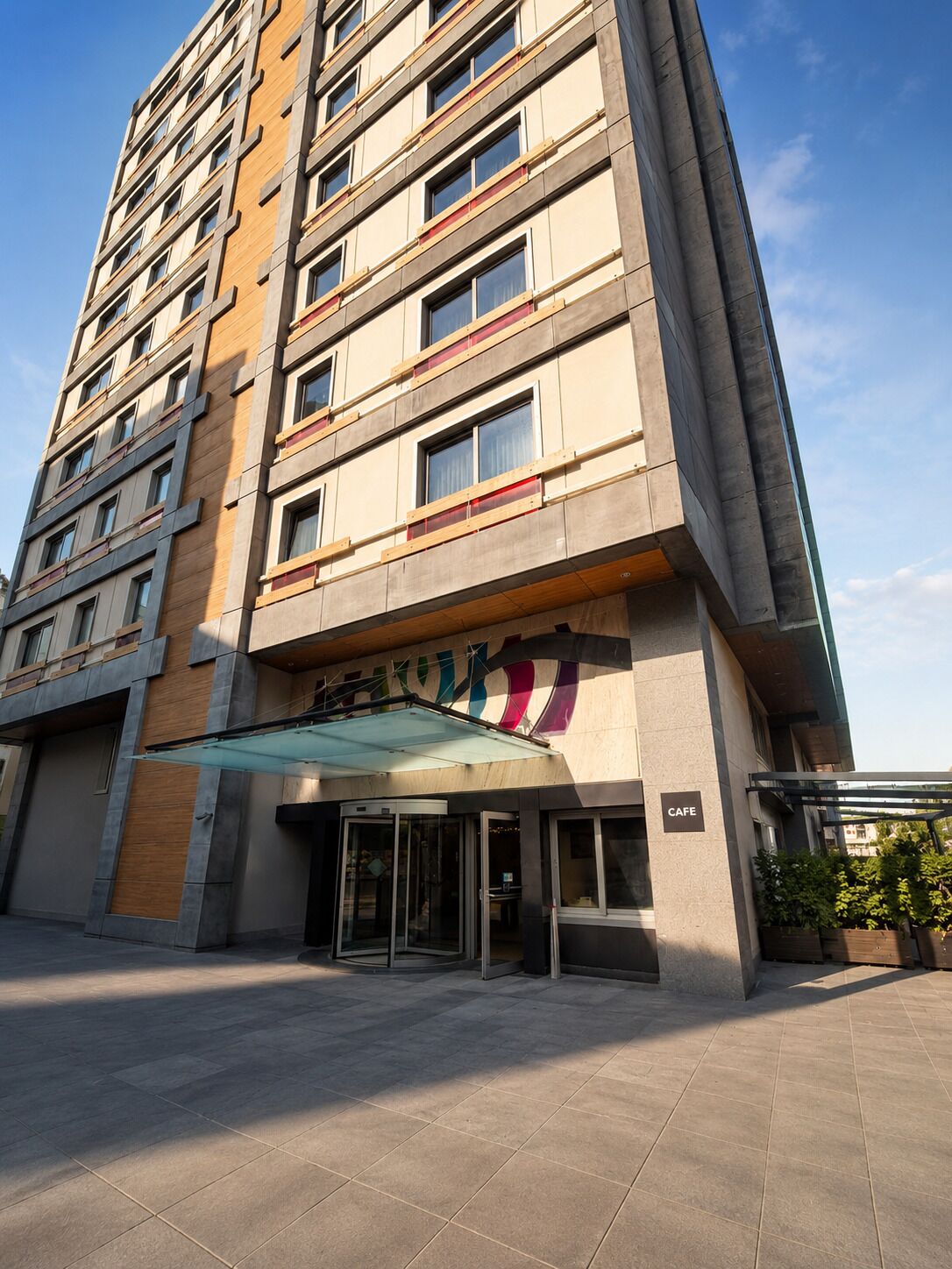 Ein mehrstöckiges Hotel mit einem Café im Erdgeschoss.