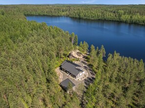 A lakeside property with a main building and a smaller structure, surrounded by dense forest. - Kalaranta by Interhome (Pertunmaa)