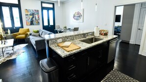 Una cocina moderna con armarios de madera oscura, encimera de granito y una isla grande con fregadero.