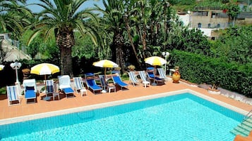 Una piscina al aire libre de temporada, sombrillas