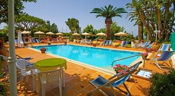 Una piscina al aire libre de temporada, sombrillas