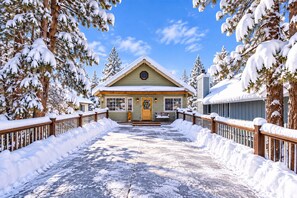 A lodge with a snow-covered entrance, wooden railings, and a clear sky. - View Point - Hot Tub + Slope Views | Game Room (Big Bear Lake)