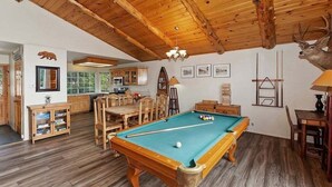 A wooden-floored room with a pool table, wooden cabinets, and a deer head decoration. - View Point - Hot Tub, Pool Table, Arcade Game, Slope Views (Big Bear Lake)
