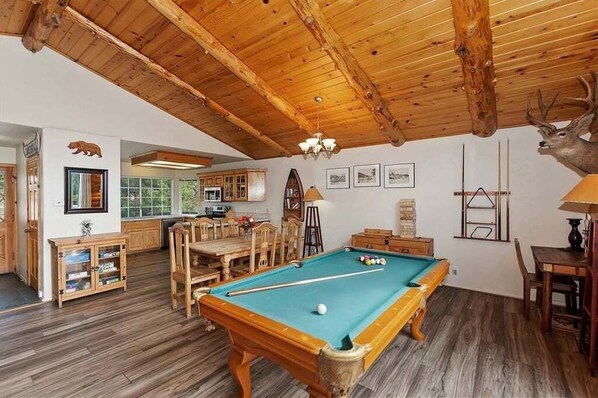 A wooden-floored room with a pool table, wooden cabinets, and a deer head decoration. - View Point - Hot Tub, Pool Table, Arcade Game, Slope Views (Big Bear Lake)