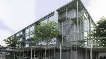 A multi-story building with a covered outdoor seating area, a staircase, and a bike rack.