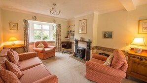 A cozy living room with a fireplace, two sofas, and a television.