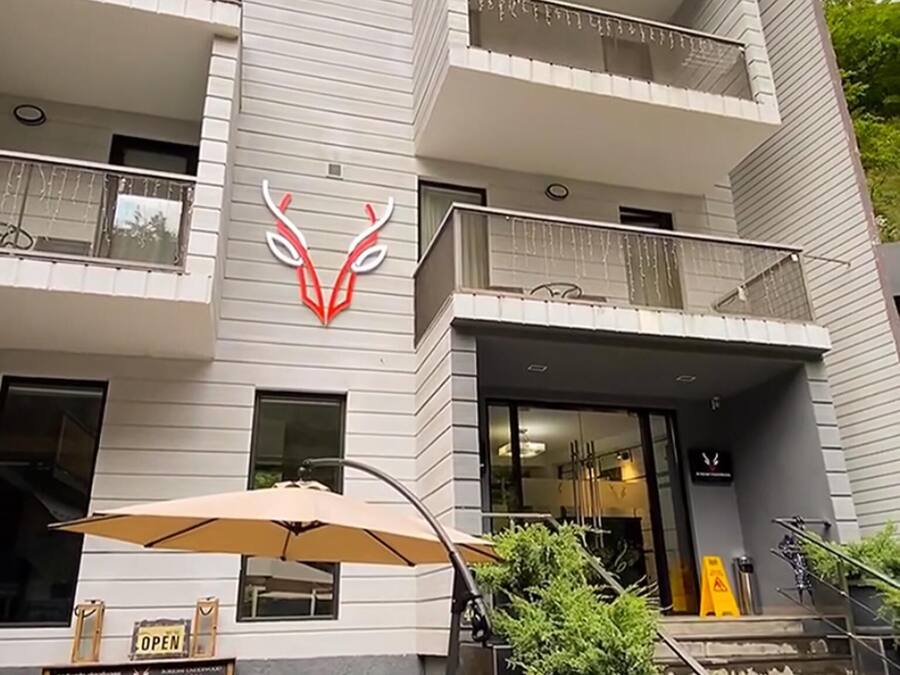 Un edificio de varios pisos con un diseño moderno, que presenta un logotipo destacado en la fachada.