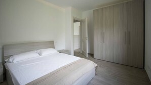 Une chambre à coucher avec un lit, une table de chevet et une armoire.