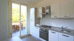 A modern kitchen with white cabinets, a gas stove, and a sink. - Apartment "G" Terrace - Levanto Cinque Terre (Levanto)