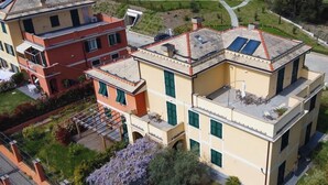 A multi-story residential building with a flat roof, large windows, and a garden area with lavender plants. - Apartment "G" Terrace - Levanto Cinque Terre (Levanto)