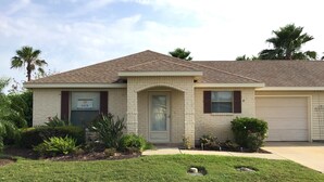 A two-story house with a brick facade, a front door, and a garage.