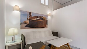Una habitación moderna con una cama, una mesita pequeña y una lámpara de pared.