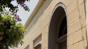 Una calle estrecha con edificios que tienen ventanas arqueadas y contraventanas.