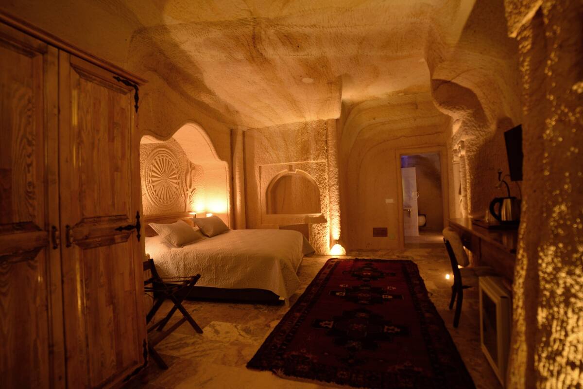 Una habitación con cama, armario de madera y alfombra.