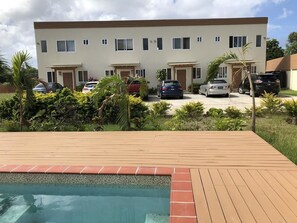 A modern two-story building with a swimming pool in the foreground.