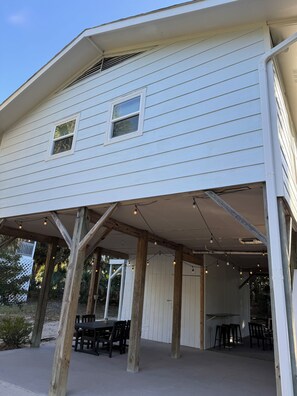 A covered outdoor area with wooden beams, a table, and chairs.