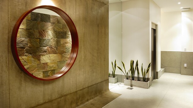 A modern interior with a stone wall, a round mirror, and potted plants. - LUXURY DUPLEX, fully equipped, 2Bd, pool & terrace (Palermo)