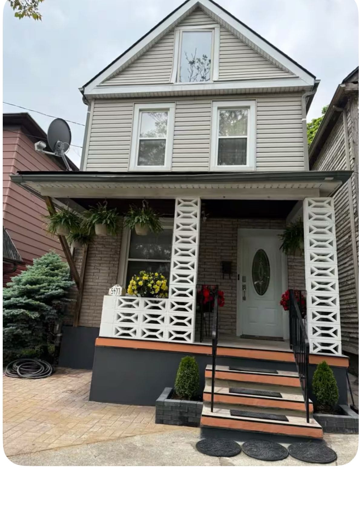 A two-story house with a front porch, a satellite dish, and a mailbox.