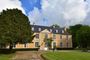 A large, two-story building with a symmetrical facade, multiple windows, and a central entrance. - Riverside Retreat in Lantheuil (Lantheuil)