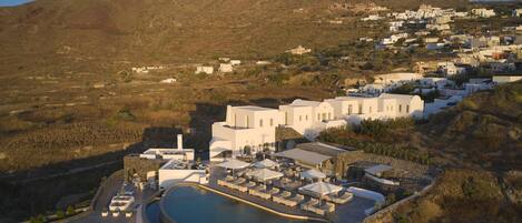 A resort with a pool area, outdoor seating, and a view of the surrounding landscape.
