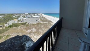 Un balcon donnant sur une plage et des bâtiments.