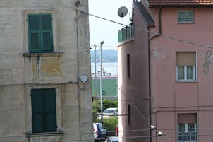 Un edificio con fachada rosa, contraventanas verdes y una antena parabólica.