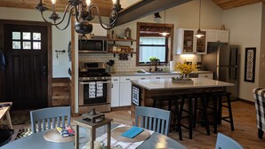 A kitchen with a central island, wooden cabinets, and a chandelier. - Great Getaway on the Big Thompson very near Estes & Rocky Mt. Nat'l Park (Drake)