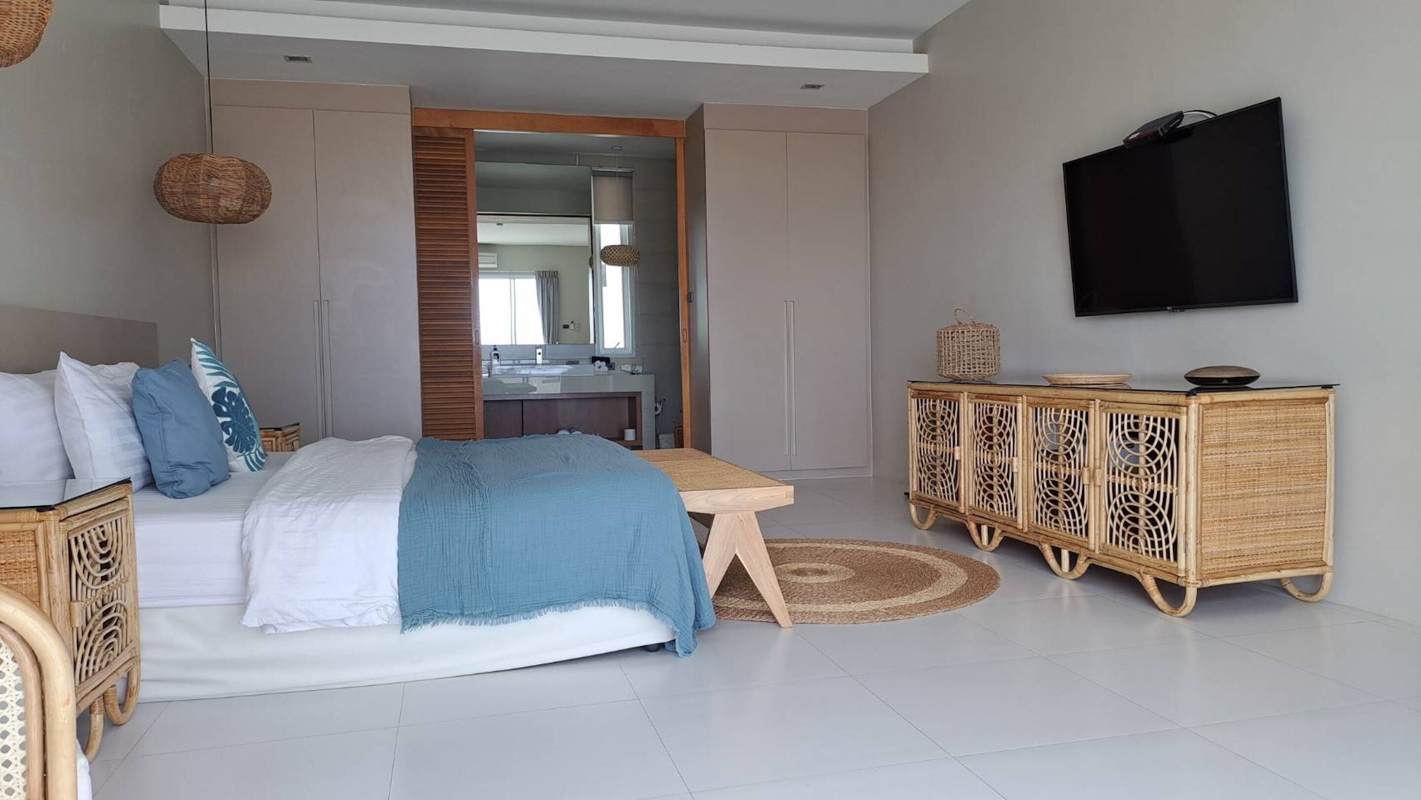 A modern bedroom with a bed, bedside table, and a television mounted on the wall.