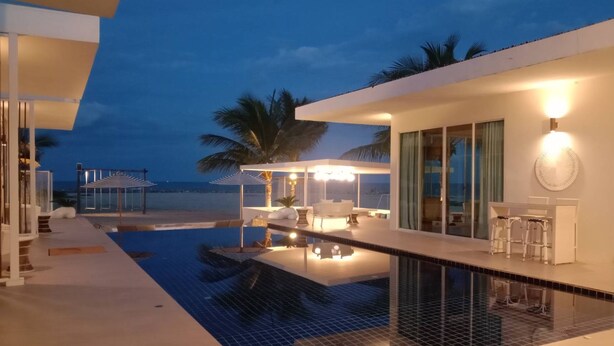Een modern resort met een zwembad, terras en uitzicht op de oceaan.