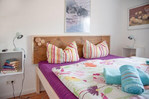 Cozy retreat with a comfortable bed, bookshelf, and bedside table.