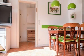 Cozy living space with a dining area, television, and dining table for four.