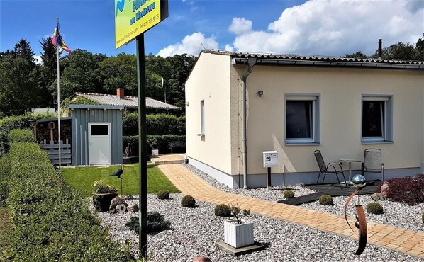 Guests can enjoy a serene garden setting with a well-maintained garden and a cozy porch area.