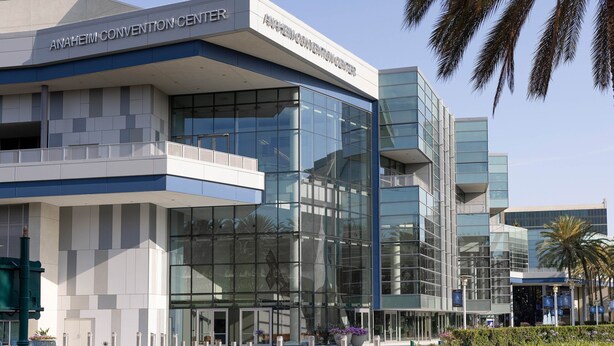 Ein modernes Gebäude mit einer Glasfassade und der Aufschrift "ANAHEIM CONVENTION CENTER" vorne.
