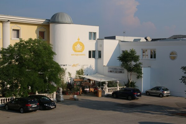 A boutique hotel with a prominent sign, parked cars, and a clear sky. - Boutiquehotel Freizeittempel (Wiener Neustadt)