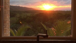 Una cocina con ventana que ofrece vistas al atardecer.