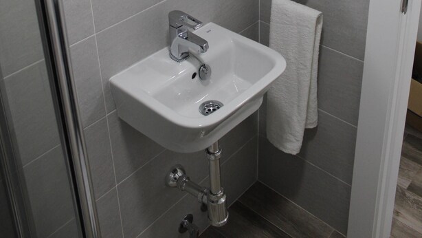A bathroom with a white sink, a mirror, and a towel hanging on a rack. - Nogalera Beach Apartment (Torremolinos)