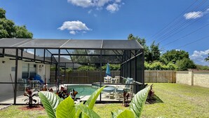 A backyard with a pool, covered patio, and outdoor furniture. - Pool home near Disney parks. (Kissimmee)
