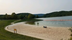 A sandy beach with a curved path, a lake, and a forested hill in the background. - Spacious! Recent Remodel! 6 Min. to Raystown Lake! Linens&Towels provided! (Saxton)