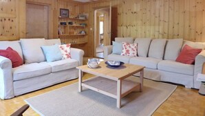 A cozy living room with two sofas, a coffee table, and a bookshelf. - Chalet Alte Post by Interhome (Schwenden)