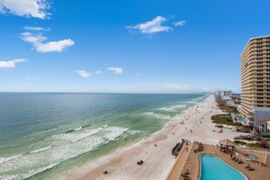 A beach resort with a pool, beach, and ocean view.