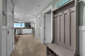 A modern kitchen with white cabinetry, a built-in oven, and a stainless steel refrigerator.